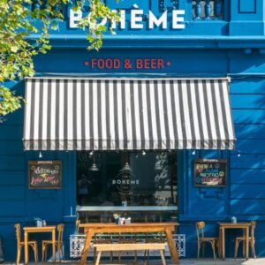 brown wooden chairs and tables near blue wooden building during daytime